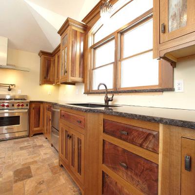 cabinets and drawers of fumed oak and crotched walnut in Arts and Crafts style